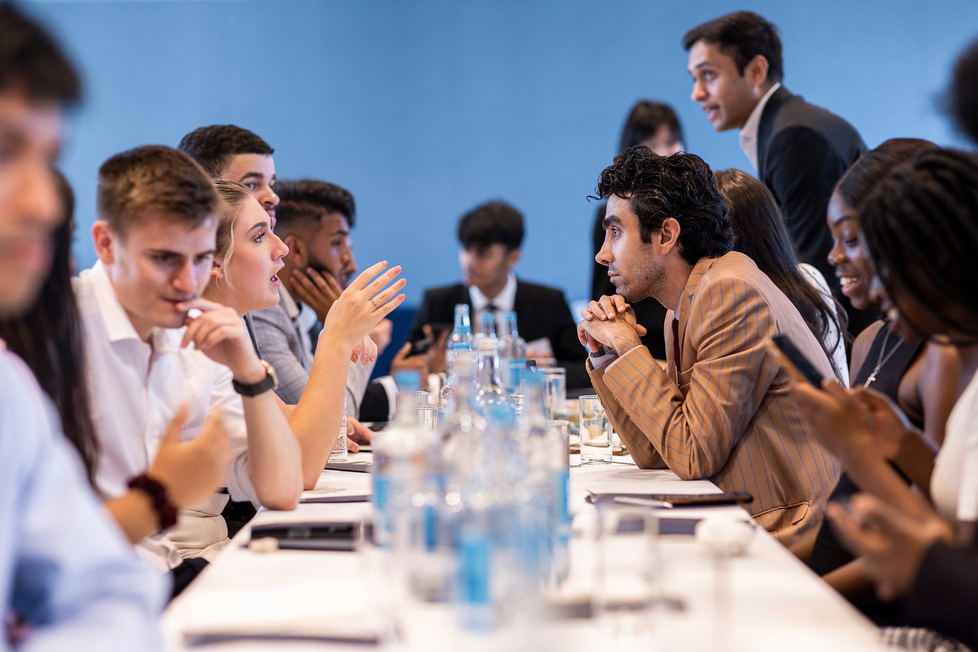 Group of Lazard Interns Talking at Long Table